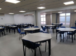 Aula de la sede de Madrid con mesas y sillas azules distribuidas en filas